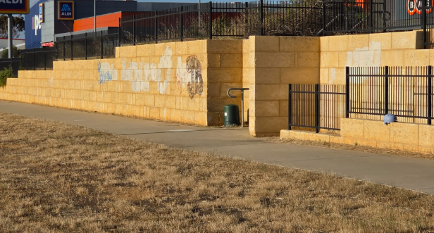 Graffiti tags painted over on a limestone wall in Geraldton, Western Australia